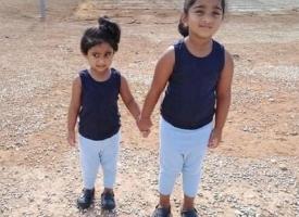 Five year old Kopika Murugappan and her sister Tharunicaa in a detention centre yard 