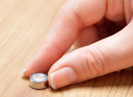 Hand holding a button battery