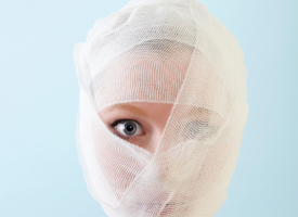 woman with bandages on her face