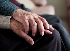 Elderly couple holding hands