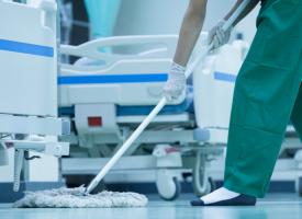 Cleaner mopping floor in hospital