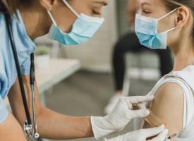 Image of nurse vaccinating teenage girl