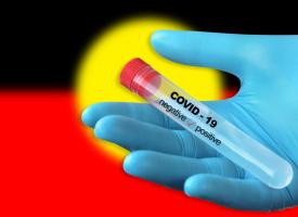 Vaccine held in front of Aboriginal flag