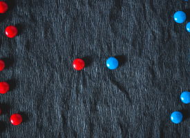 red smarties on left blue smarties on right one red and one blue in the middle 