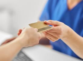 person handing over private health card