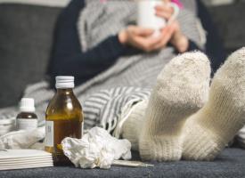 Image of person with warm socks and used tissues