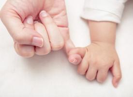 mother and baby's hands intertwined