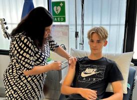 Teen receiving vaccine