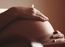 Image of a pregnant woman's belly and hands