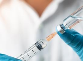 Doctor extracting a vaccine from a viral into a syringe