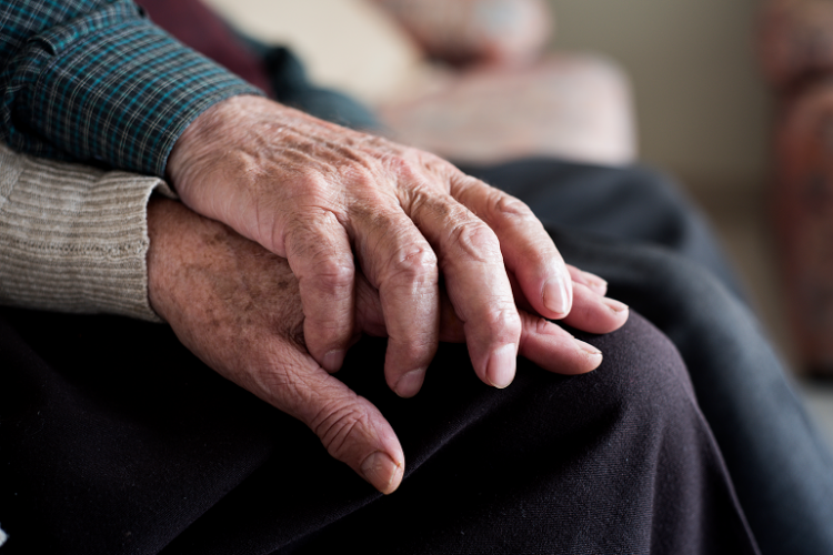 Elderly couple holding hands