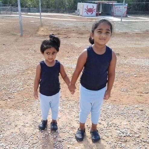 Five year old Kopika Murugappan and her sister Tharunicaa in a detention centre yard 