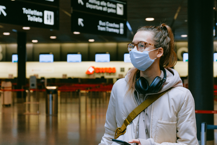 Woman wearing a surgical mask while travelling through airport