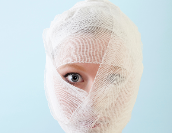 woman with bandages on her face