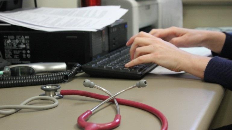 Doctor views computer at desk