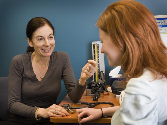 A GP consults with a woman in her surgery.