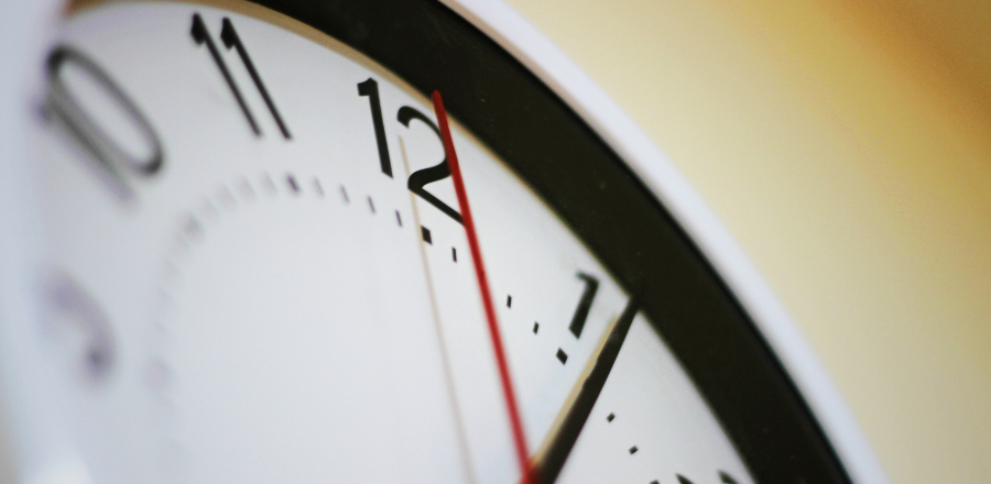 Close up of part of a clock face with the second hand on 12